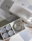 Aesthetic overhead view of the premium velvet scented tealight candle gift box arranged across minimalist design magazines.
