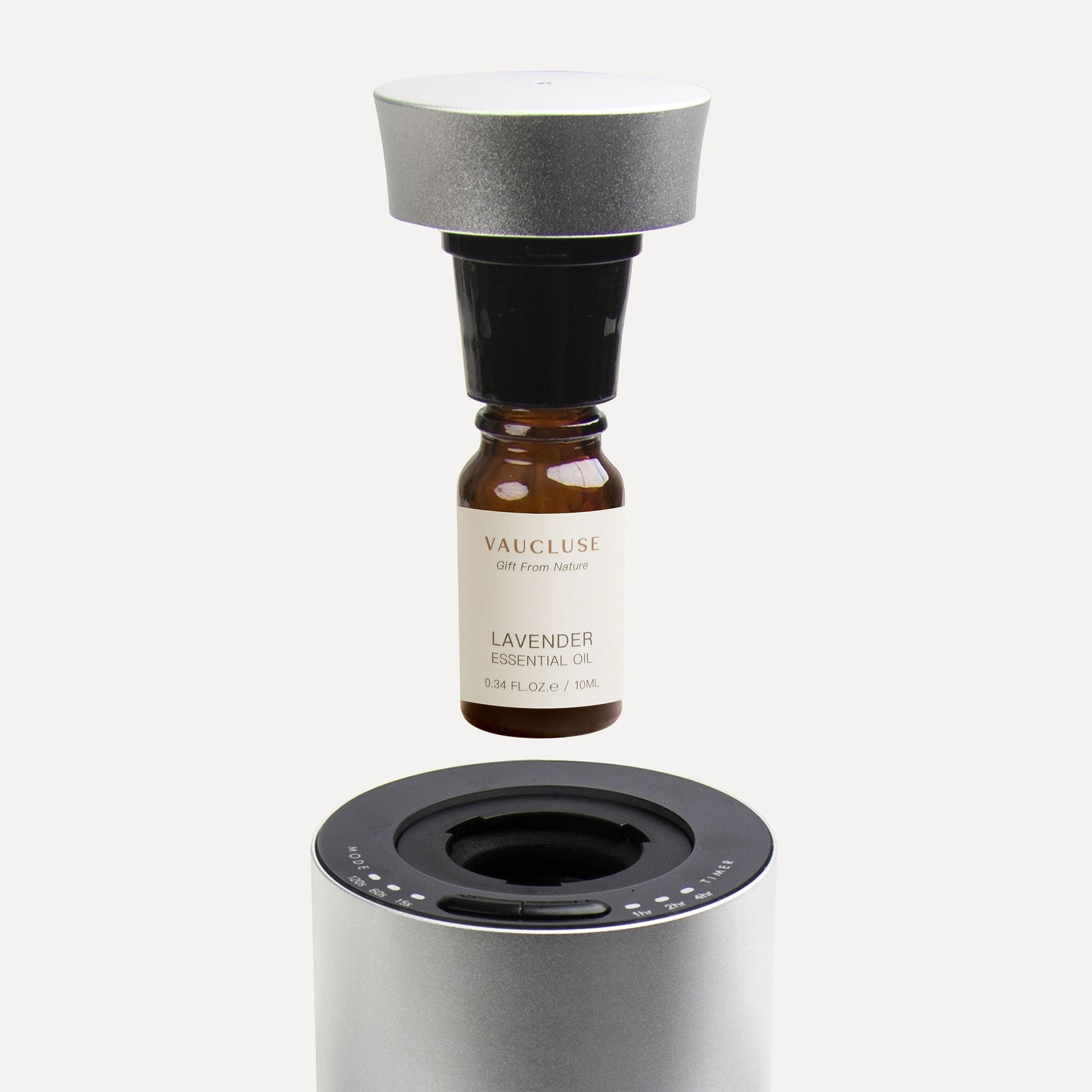 Lavender EssenAn instructional close-up showing a 10ml lavender essential oil bottle screwing into a black nozzle mechanism above a silver waterless diffuser.tial Oil - 10ml - VAUCLUSE