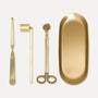 Premium gold candle care accessory set featuring a wick trimmer, candle snuffer, wick dipper, and matching oval tray on a clean background.
