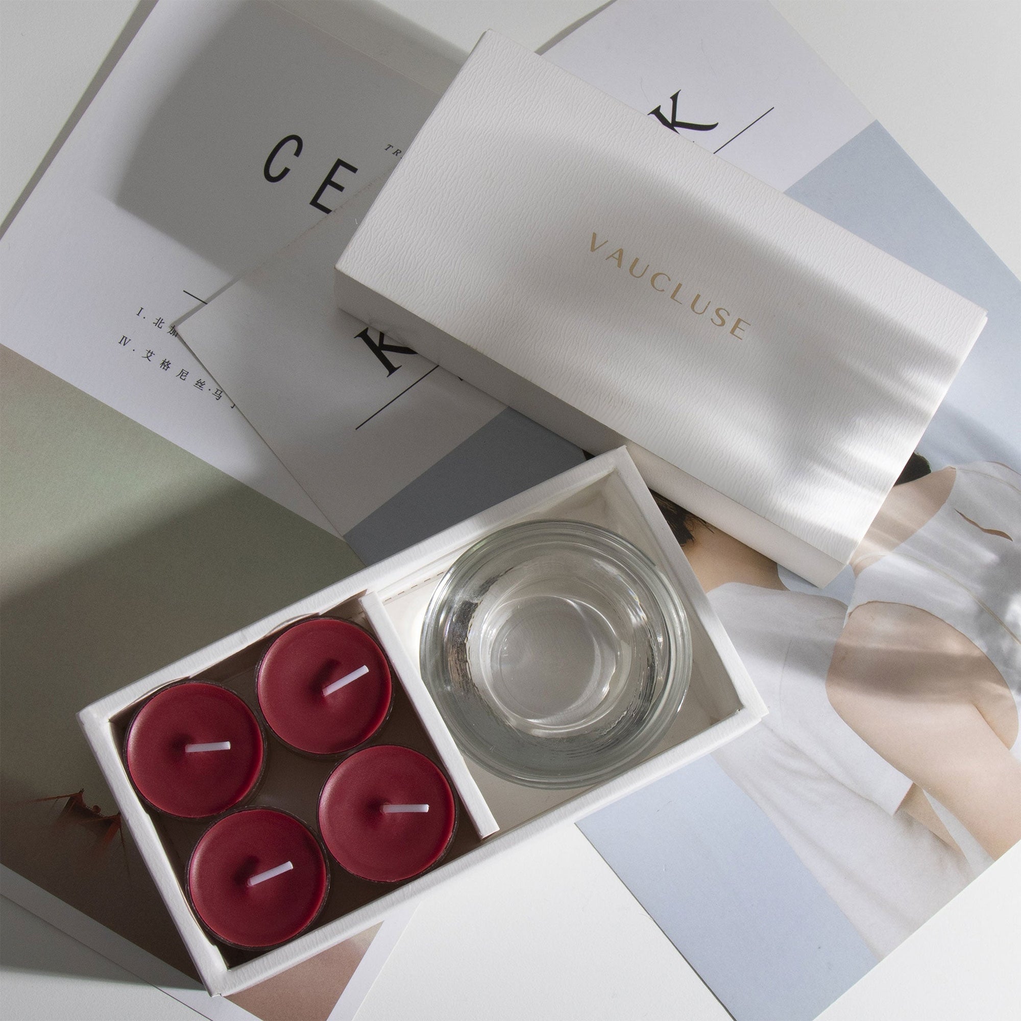 Aesthetic top-down view of the premium berry scented tealight candle gift box arranged over modern minimalist design books.
