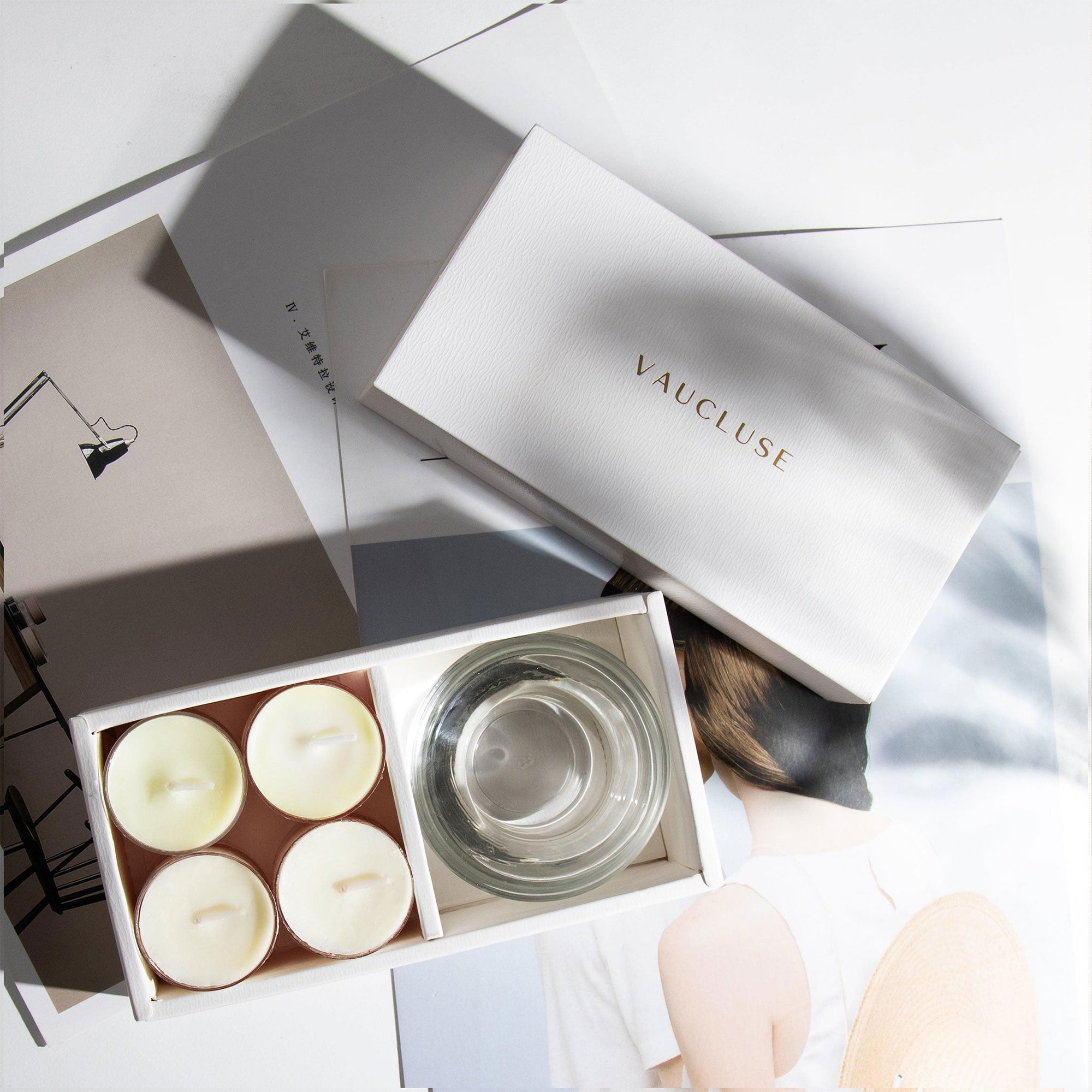 Overhead aesthetic view of the premium jasmine scented tealight candle gift set arranged on top of minimalist design books and magazines.