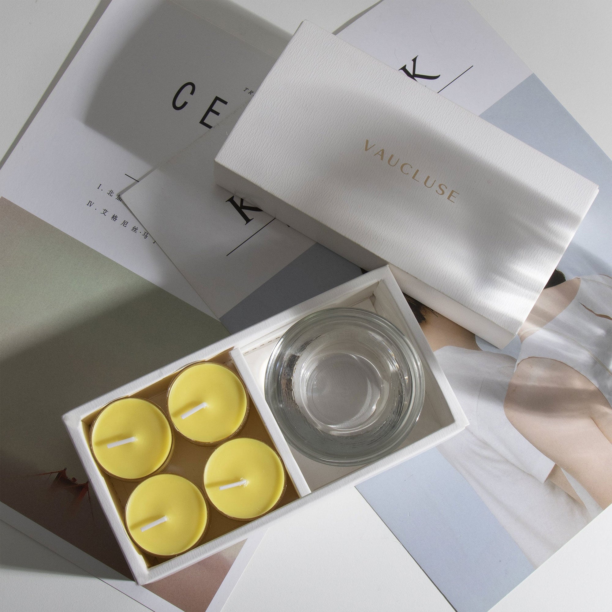 Aesthetic top-down view of the premium lemon scented tealight candle gift box arranged over modern minimalist design books.