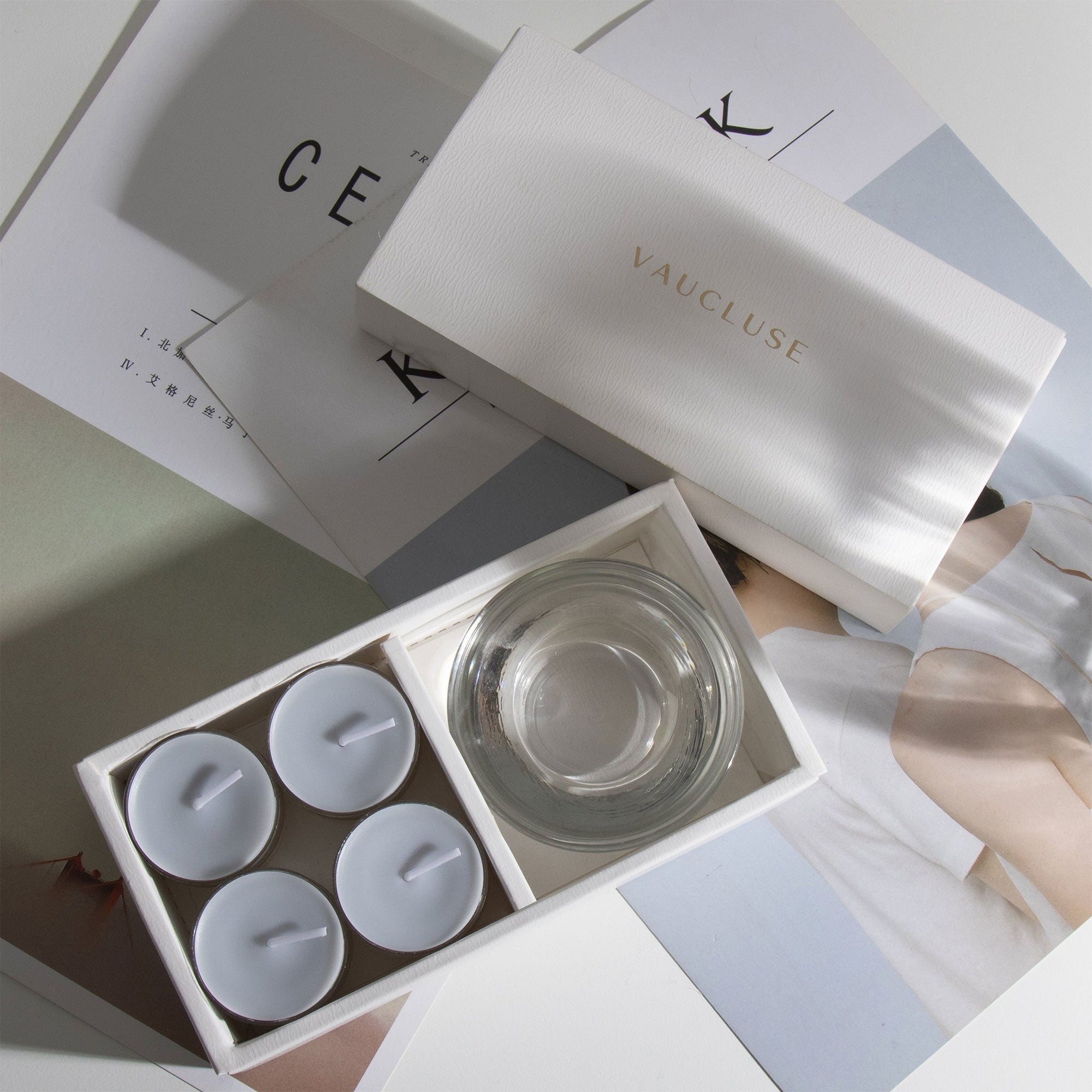 Aesthetic overhead view of the premium velvet scented tealight candle gift box arranged across minimalist design magazines.