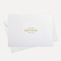 Overhead view of a minimalist luxury white birthday greeting card featuring gold foil text "Happy Birthday To You" paired with a matching white paper envelope.