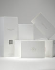 A curated collection of premium minimalist white Vaucluse fragrance boxes, candle packaging, and the elegant With Love Always card neatly arranged on a white surface.