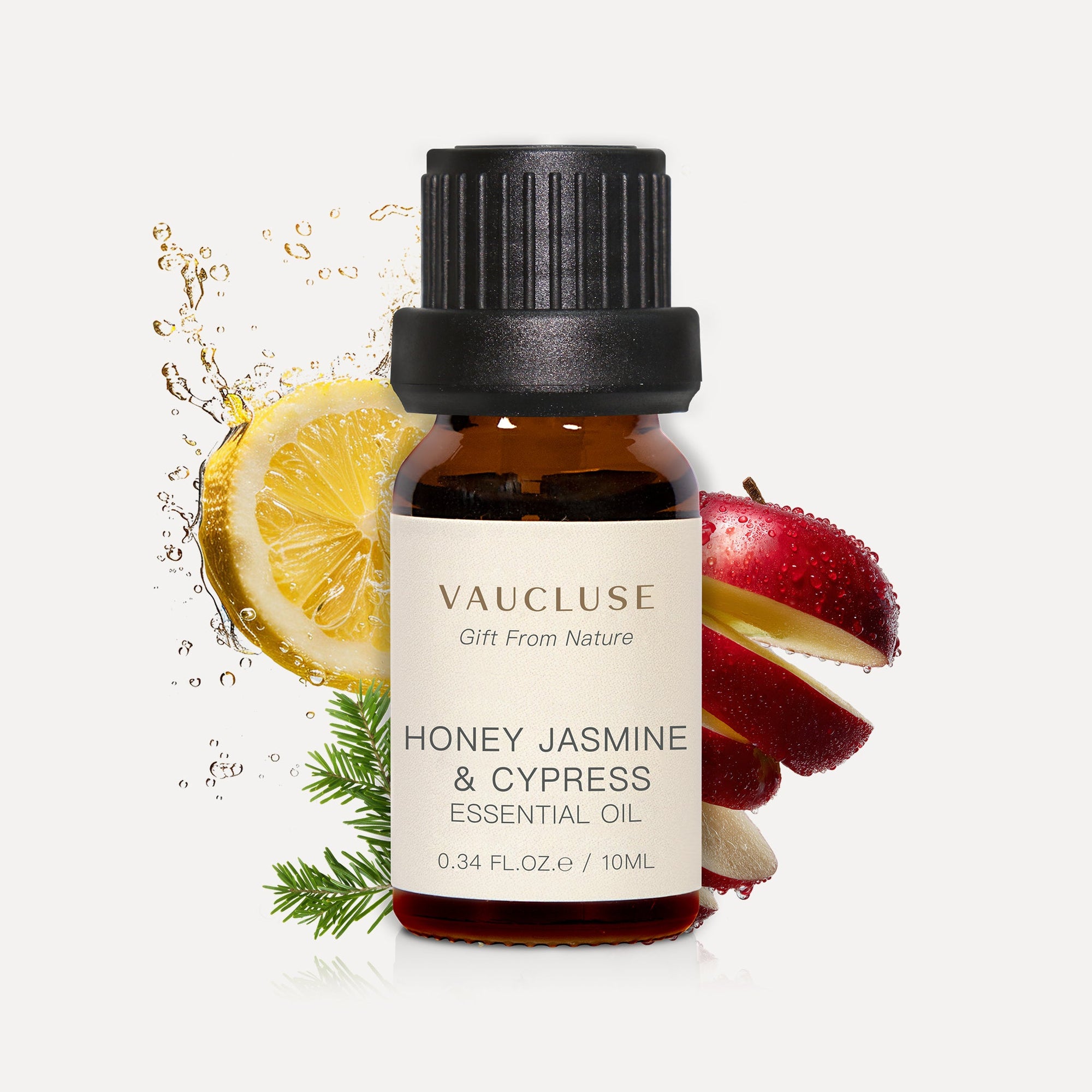 Vaucluse 10ml Honey Jasmine and Cypress essential oil amber glass bottle styled with fresh lemon slices, red apple peel, and cypress sprigs.