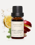 Vaucluse 10ml Honey Jasmine and Cypress essential oil amber glass bottle styled with fresh lemon slices, red apple peel, and cypress sprigs.