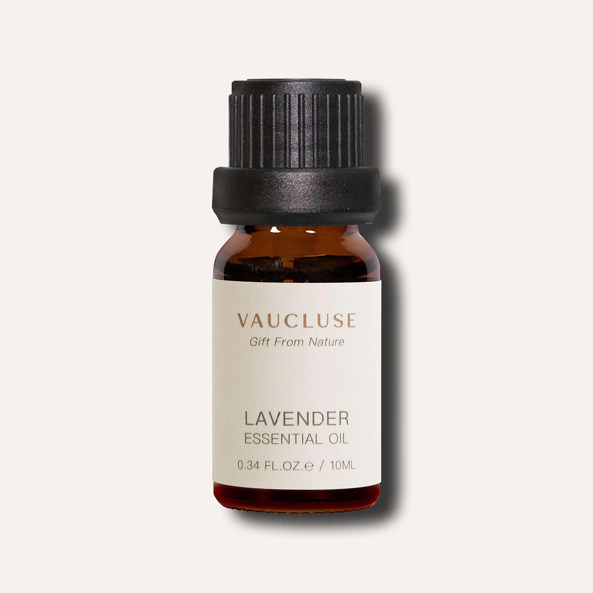 A minimalist e-commerce studio shot of a 10ml amber glass bottle of Vaucluse Lavender Essential Oil with a black ribbed cap.