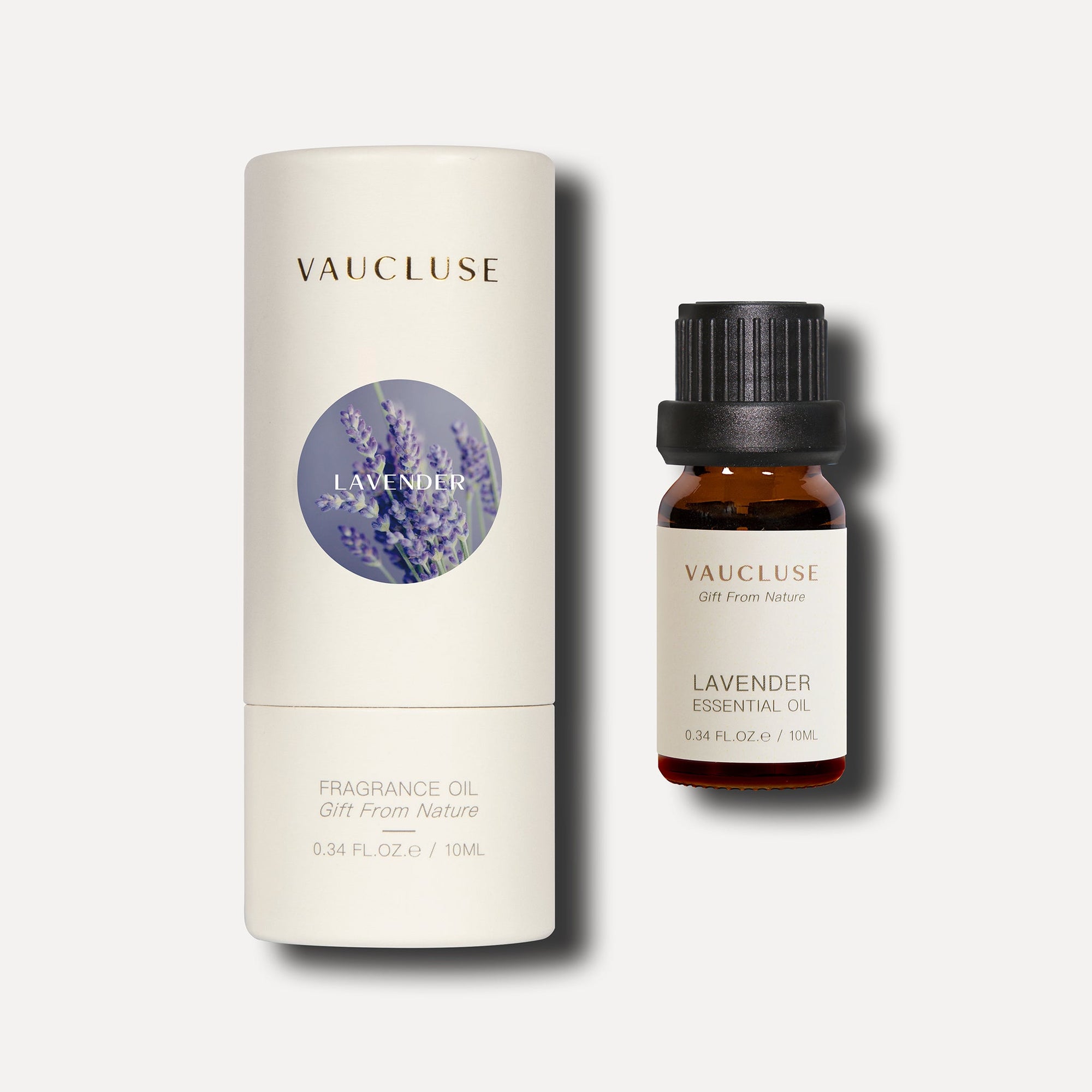 A 10ml amber bottle of Vaucluse lavender essential oil standing beside its white cylindrical protective packaging tube.