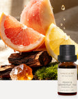 Vaucluse Peach and Grapefruit Tea essential oil bottle alongside fresh peach, citrus fruits, and natural amber resin.