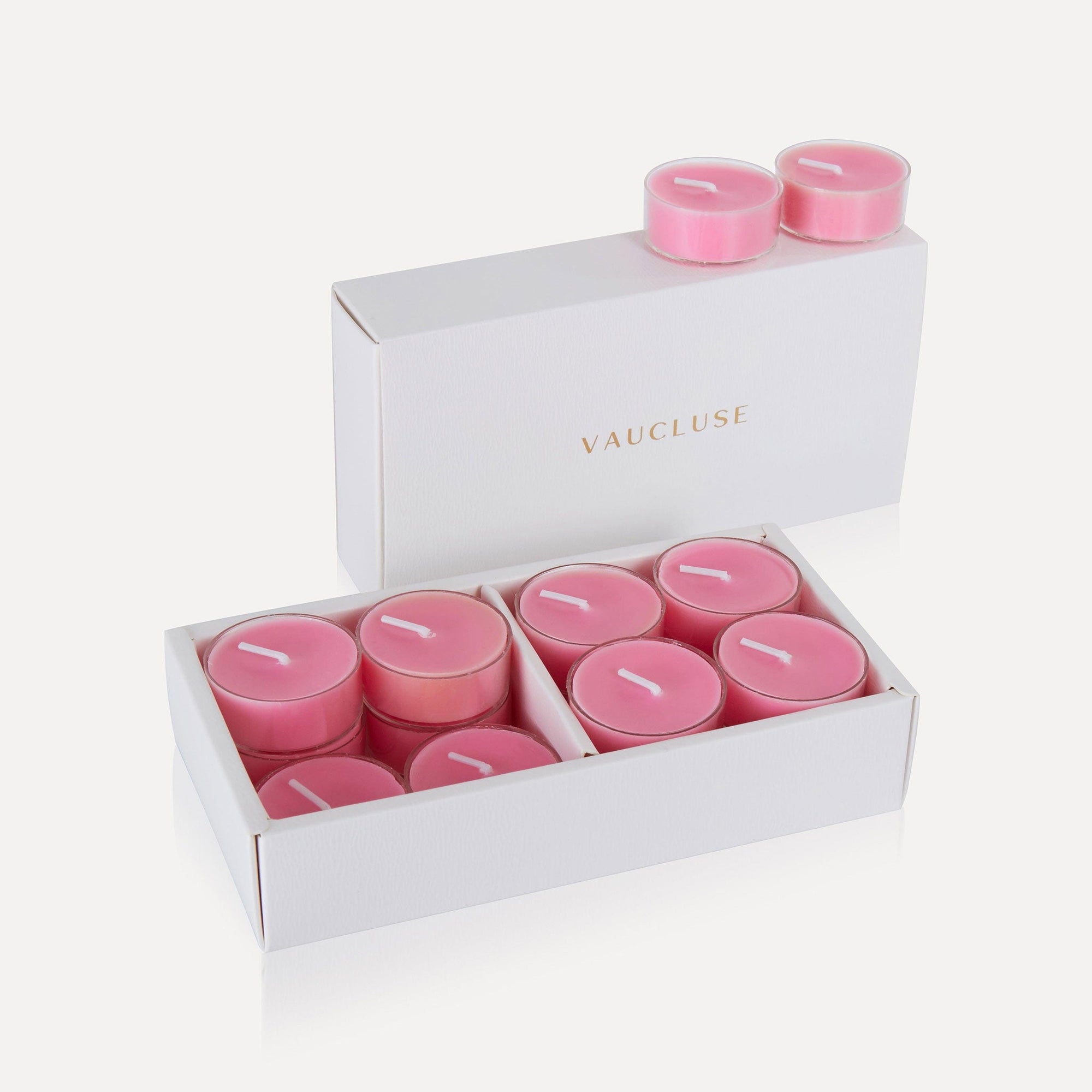 An open luxury white Vaucluse box displaying a full set of pink rose scented tealight candles.