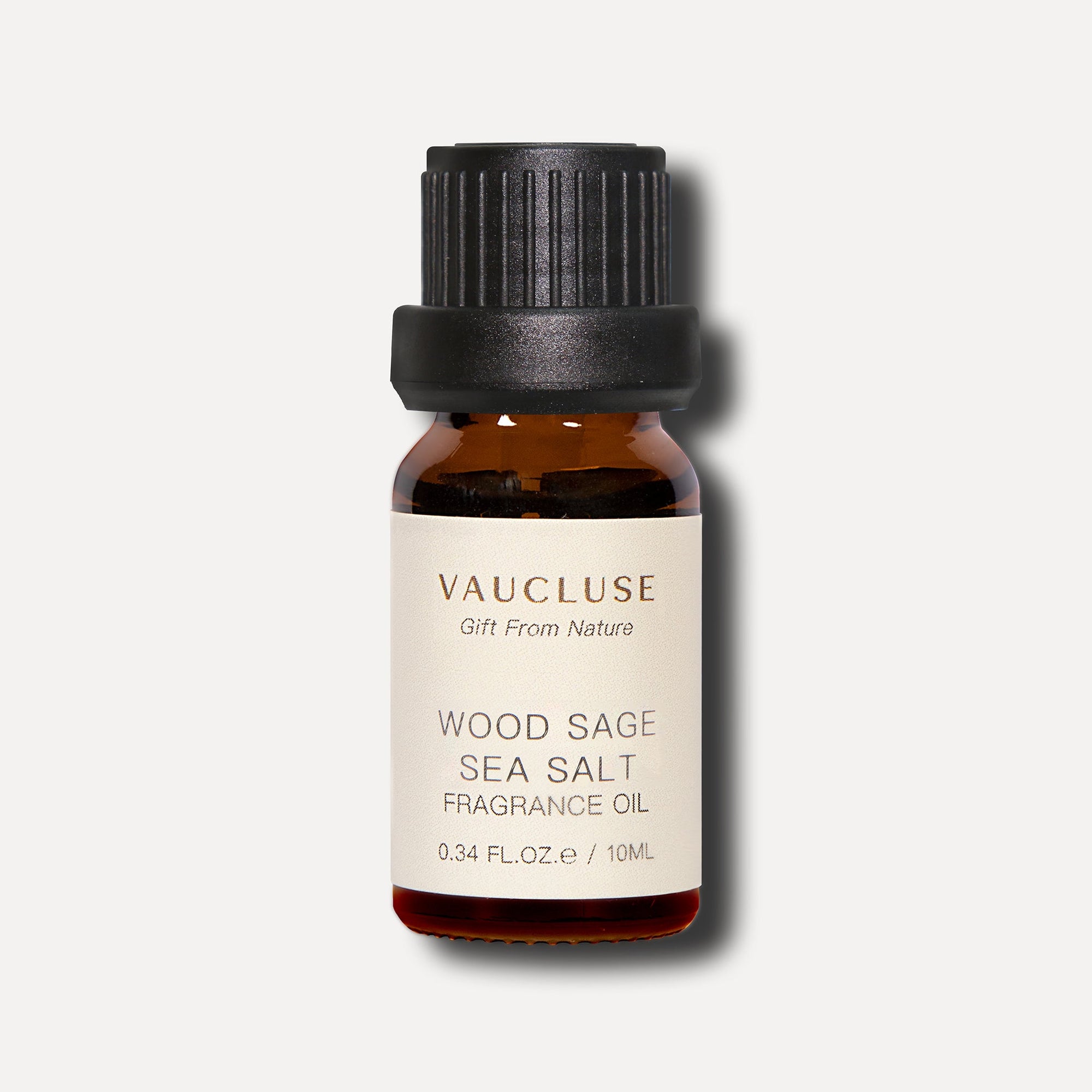 A clean studio front shot of a 10ml amber glass bottle of Vaucluse Wood Sage Sea Salt Essetial Oil with a black ribbed screw cap.